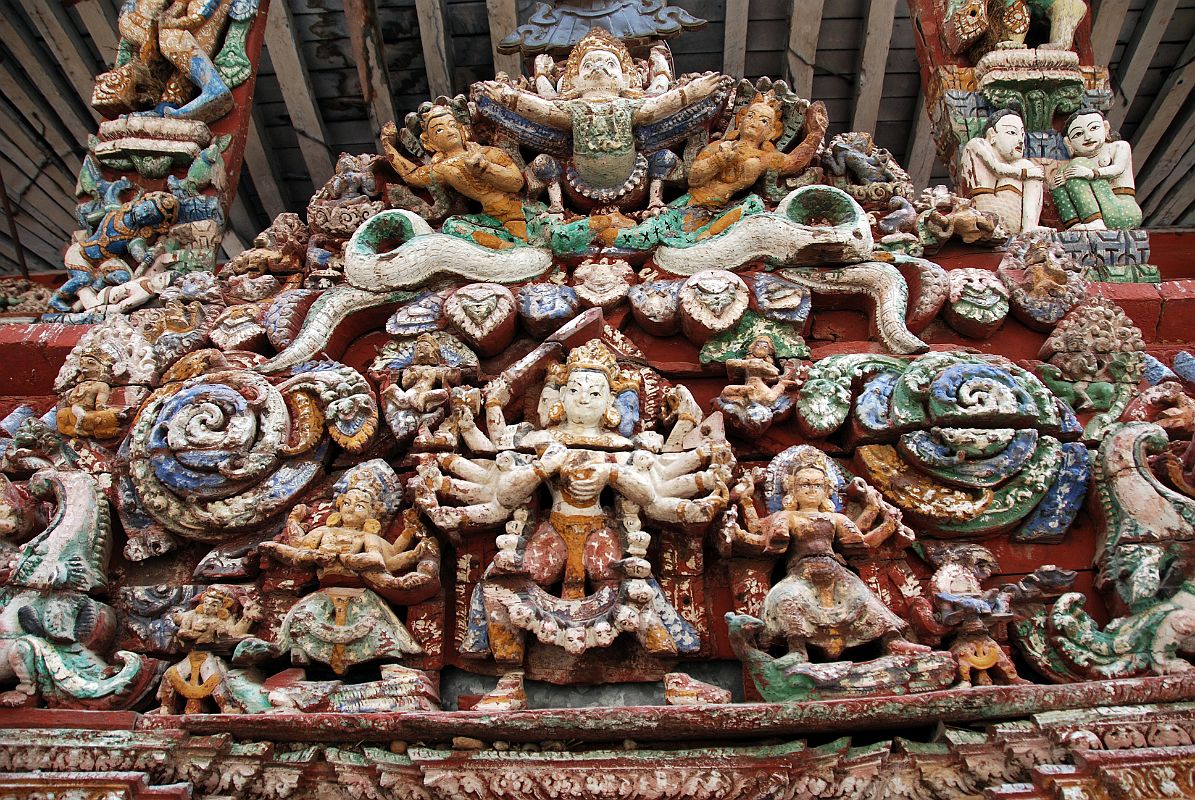 Kathmandu Patan 02-2 Rato Red Machhendranath Temple One Of The Carved Doorways Close Up With Garuda At Top And Figure With Three Heads and Eight Arms Below 